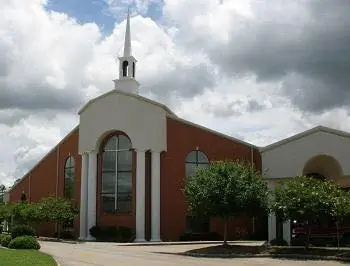 A brick church exterior with a steeple