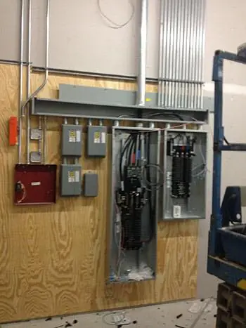 Interior commercial panel board with the deadfront off and multiple breakers exposed during a Crown Electric repair