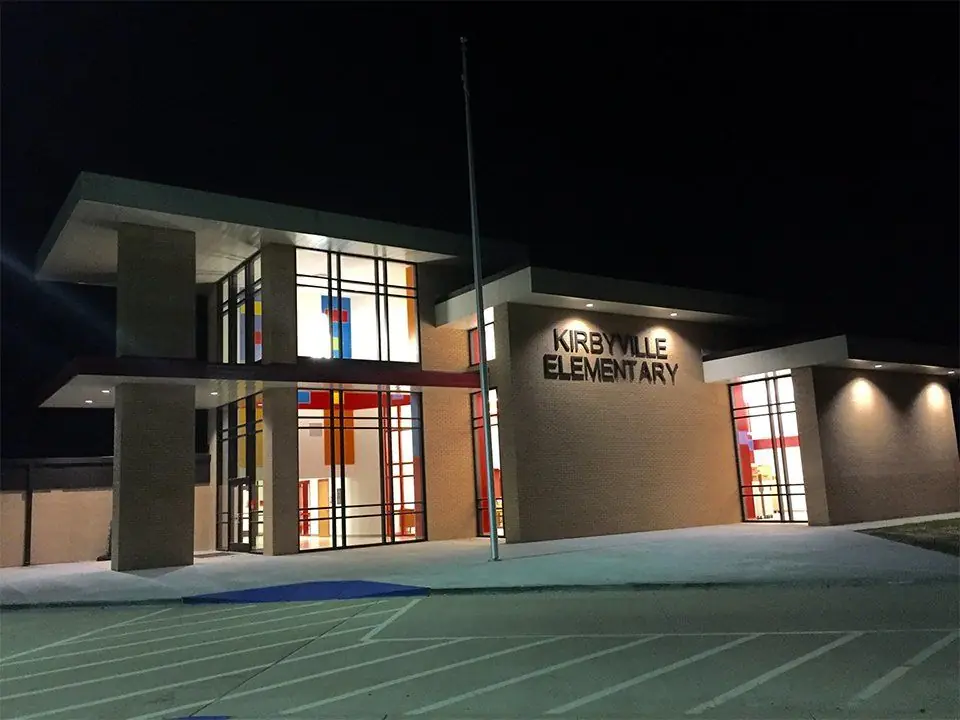 A Golden Triangle school lit after dark, exterior architectural lighting and illuminated glazing