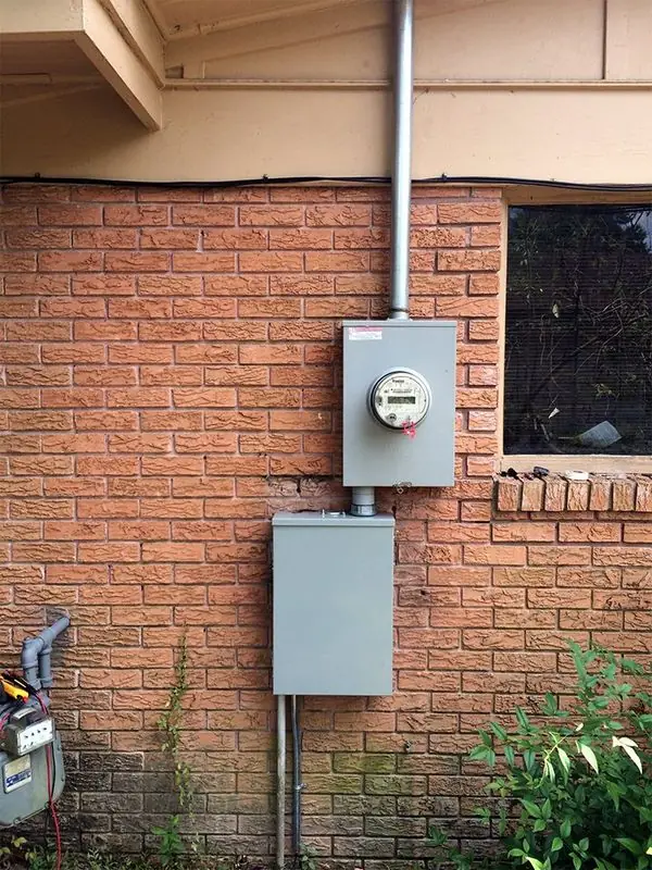 New electrical meter and service panel installed on the brick exterior of a Beaumont home